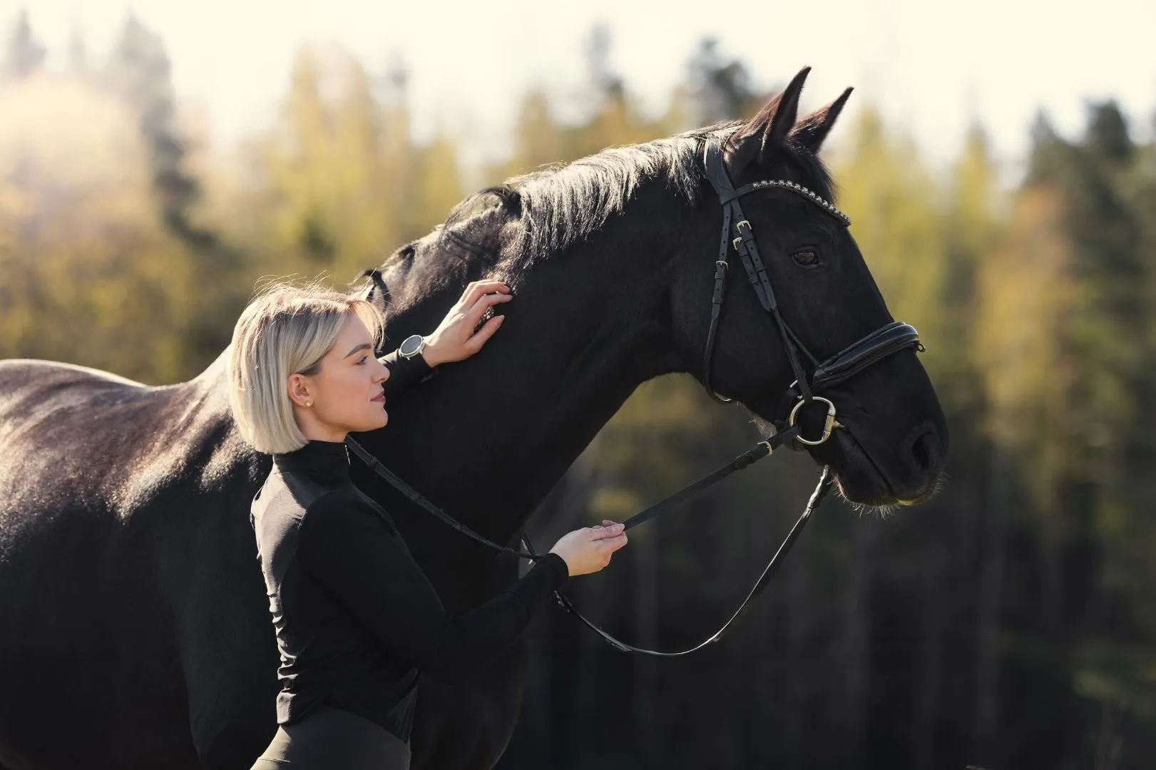 Eerika Huovinen hevosen kanssa yhteiskuvassa ulkona.